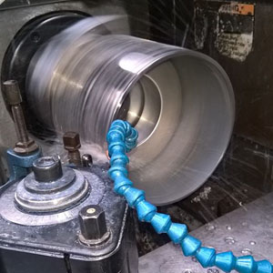 USI64- Conception de pièces sur machine -2 Machine en action, usinage de métal avec un liquide de refroidissement.