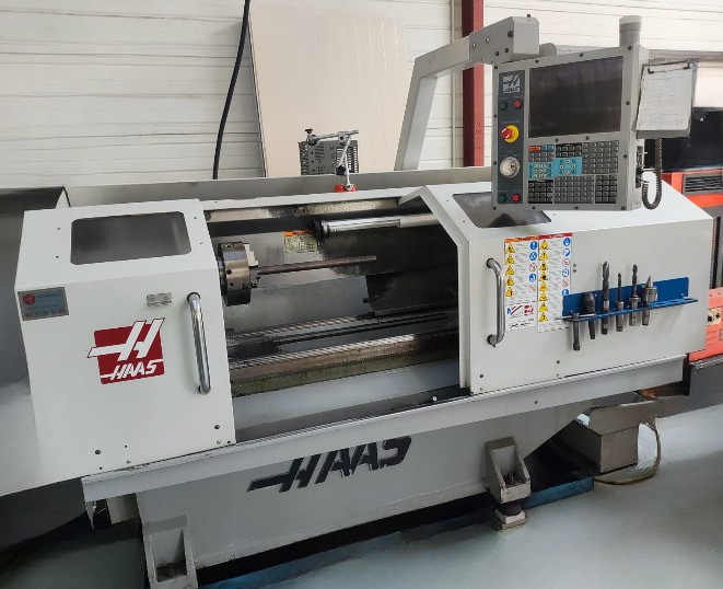 Tour CNC Haas avec commandes numériques et espace de travail.